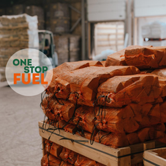 Stack of firewood with 'One Stop Fuel' logo in a warehouse setting