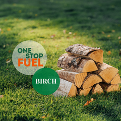 Stack of birch logs on grass with The OneStopFuel